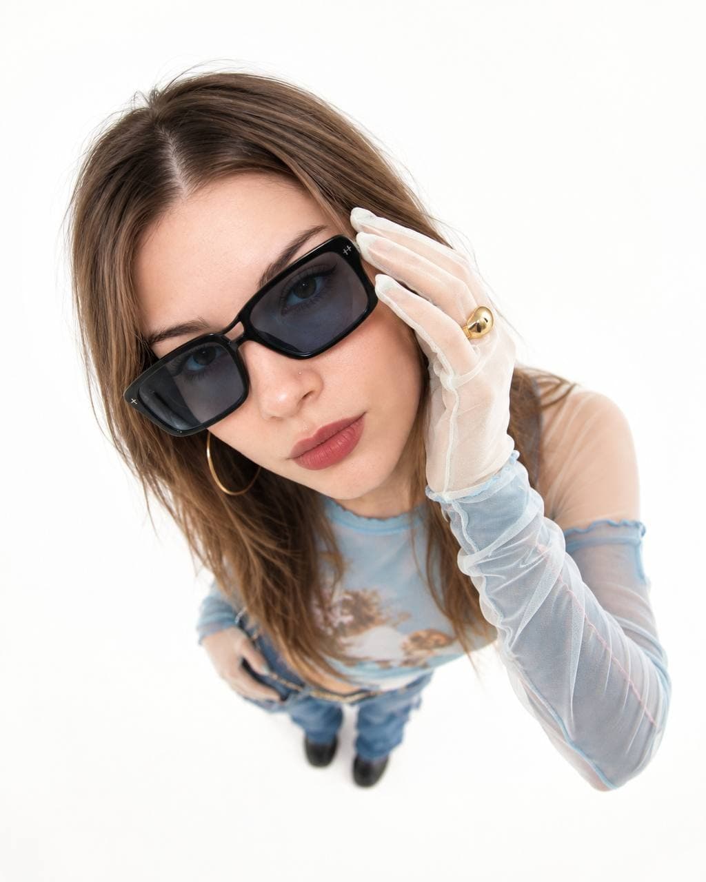 Polina shot from above: dark glasses, transparent gloves, looking into the camera